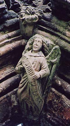 Carved figure of an angel holding a tun,
              with ‘dern’ written across its breast, a pun on Abbot
              John Darnton's surname