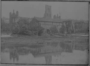 Photograph on glass plate showing the laybrothers reredorter building and grounds of Kirkstall Abbey after the re-opening as a public park in 1895. The large pool in the foreground is for skating in winter but it has long since been filled in.